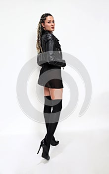 Stylish rock n roll ballerina girl with blonde braids posing in studio on isolated background. Style, trends, fashion concept.