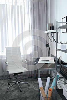 Stylish room interior with comfortable workplace near window. Design idea