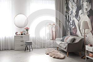 Room interior with dressing table, mirror, sofa and floral wallpaper