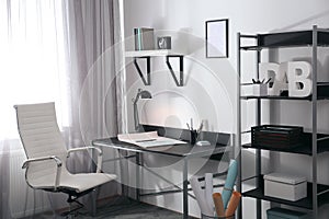 Stylish room interior with workplace near window. Design idea