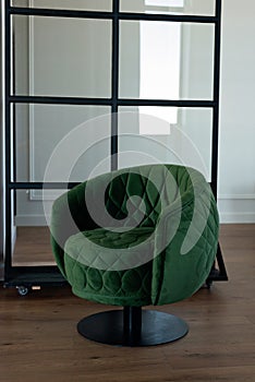 Stylish round green velvet armchair in a modern interior. Soft selective focus