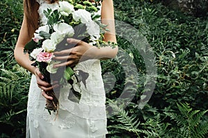 Stylish rustic bouquet in the hand of gorgeous boho bride on the