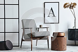 Stylish scandinavian composition of living room with design armchair, black mock up poster frame, commode, wooden stool, plant.