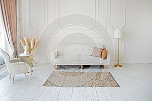 Stylish Scandinavian modern white cozy eco interior in minimalist style. Modern home decor with Pampas grass in vase. Open space.