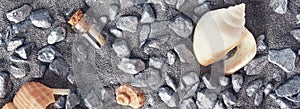 Stylish sea background. grey sand, shells, rocks and a small glass bottle with a message