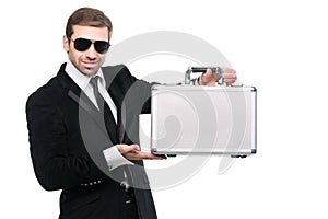 Stylish security guard presenting a metal suitcase.