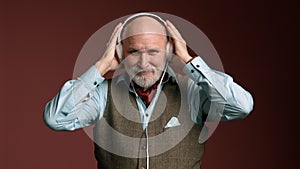 Stylish Senior in Glasses and Waistcoat Listening to Music, Bald with Gray Beard