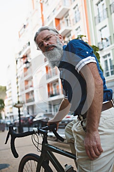 Stylish senior man with his bicycle in the city