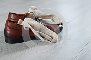 Stylish shoes with dirty socks on white wooden floor indoors, space for text