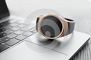 Stylish smart watch on laptop, closeup view