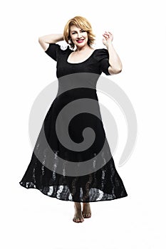 Stylish smiling middle-aged woman in a black flying dress on a white background. Healthy lifestyle and activity. Vertical