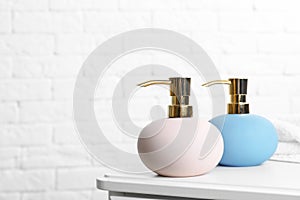 Stylish soap dispensers on table