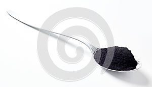 Stylish spoon heaped with edible charcoal photo