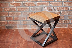 Stylish stool against a red brick wall