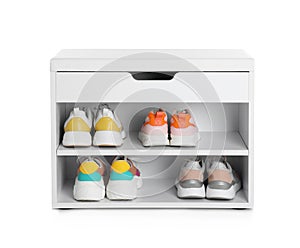 Stylish storage cabinet with different pairs of shoes on white background