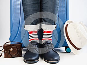 Stylish suitcase, men`s legs and multicolored socks