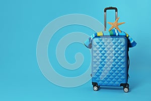 Stylish suitcase with towel and sea star on color background