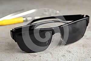 Stylish sunglasses and fixing tools on table