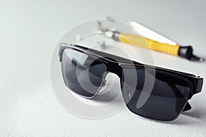 Stylish sunglasses and fixing tools on table