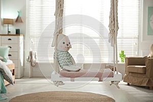 Stylish swing with toy in child`s room. Interior design