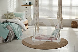 Stylish swing with toy in child`s room. Interior design