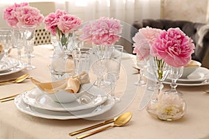 Stylish table setting with beautiful peonies and fabric napkins indoors