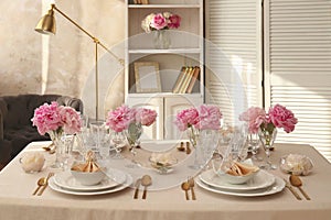 Stylish table setting with beautiful peonies and fabric napkins indoors