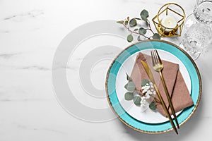 Stylish table setting with cutlery, flower and eucalyptus leaves, flat lay. Space for text