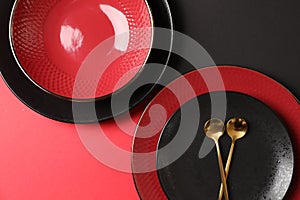 Stylish table setting with plates and spoons on color background, top view