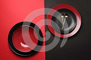 Stylish table setting with plates and spoons on color background, top view