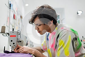 stylish tailor working on sewing machine