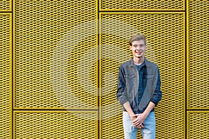 Stylish teen boy over industrial yellow background smiling