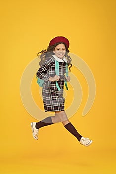 stylish teen college student jumping. little girl with backpack going to school. education concept. school and fashion