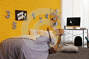 Stylish teenager`s room interior with computer and bed