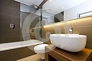 Stylish three piece bathroom suite with dark tiled walls