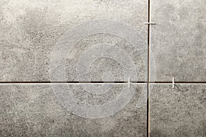 Stylish tiles with spacers on wall in room