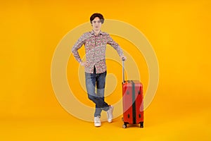 Stylish traveler leaning on suitcase