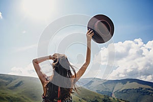 Stylish traveler woman looking at mountains. hipster girl on top