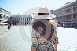 Stylish traveller woman in floral dress enjoying promenade photo