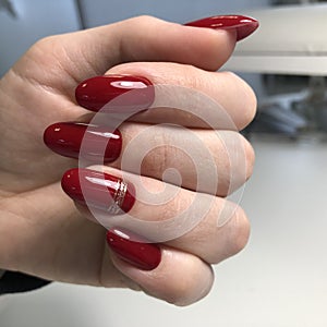 Stylish trendy red female manicure.Hands of a woman with red manicure on nails