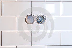 Stylish trendy white ceramic tile with a chamfer on the kitchen wall with electrict section