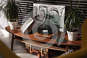 Stylish turntable with vinyl discs on table in room