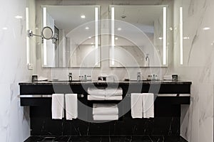 Stylish twin bathroom with two sinks and mirror. photo