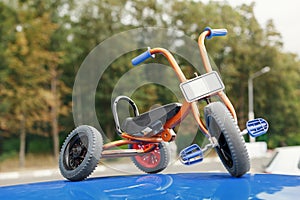 Stylish and unusual tricycle on the roof of the car