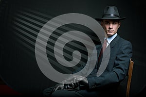 Stylish vintage detective posing on a chair