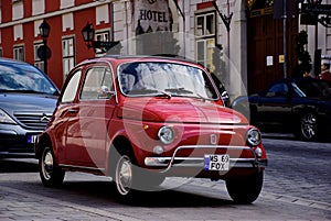 Vintage red FIAT 500 small Italian car in side view. grunge stucco elevation background