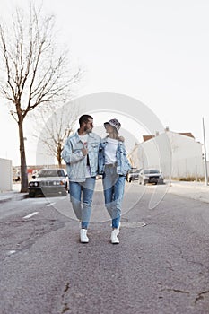 Stylish vintage young couple walking on the road