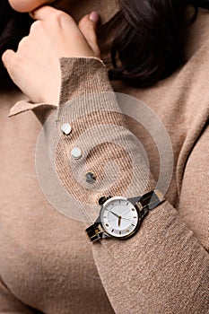 Stylish watch on woman hand. golden analog wrist watch