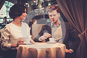 Stylish wealthy couple drinking coffee