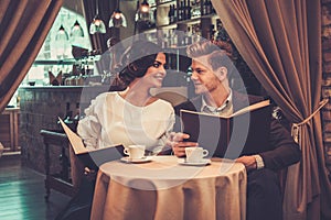 Stylish wealthy couple with menu photo